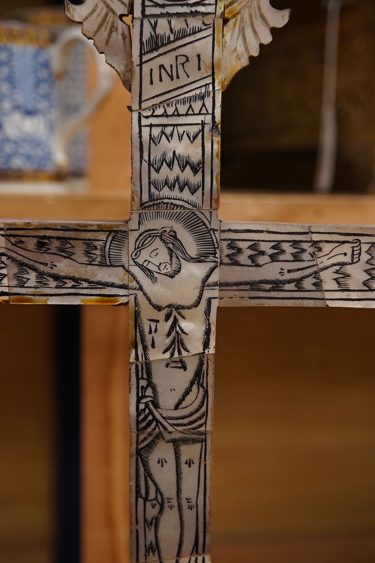 Two 19th century walnut and mother-of-pearl inlaid crucifixes and a German ebonised and white and metal mounted crucifix and a pair of Dutch or German brass tripod base cricket candlesticks, largest 56cm high (5)